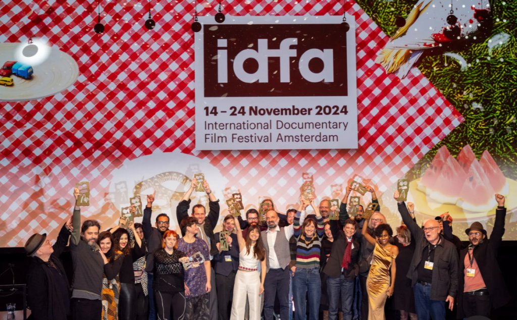 Winners at IDFA celebrate in a group picture holding up their awards